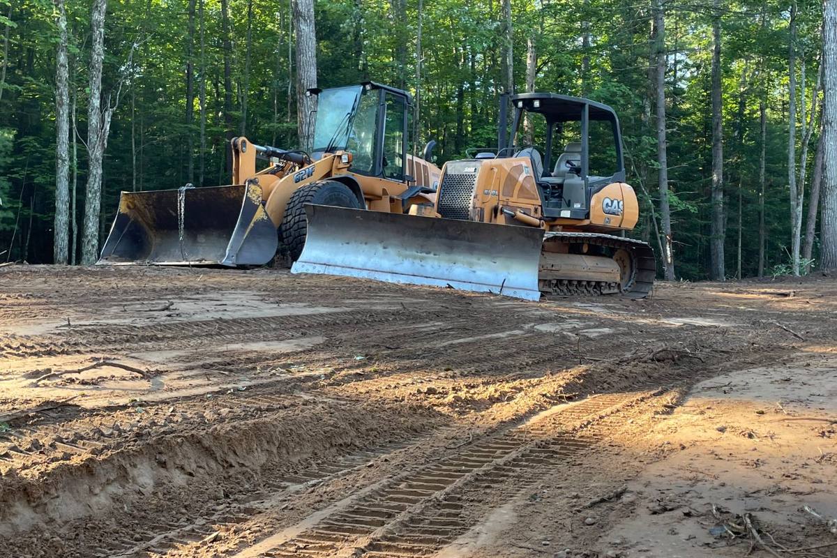 Case wheel loader and Case dozer parked side by side on a site cleared from the woods