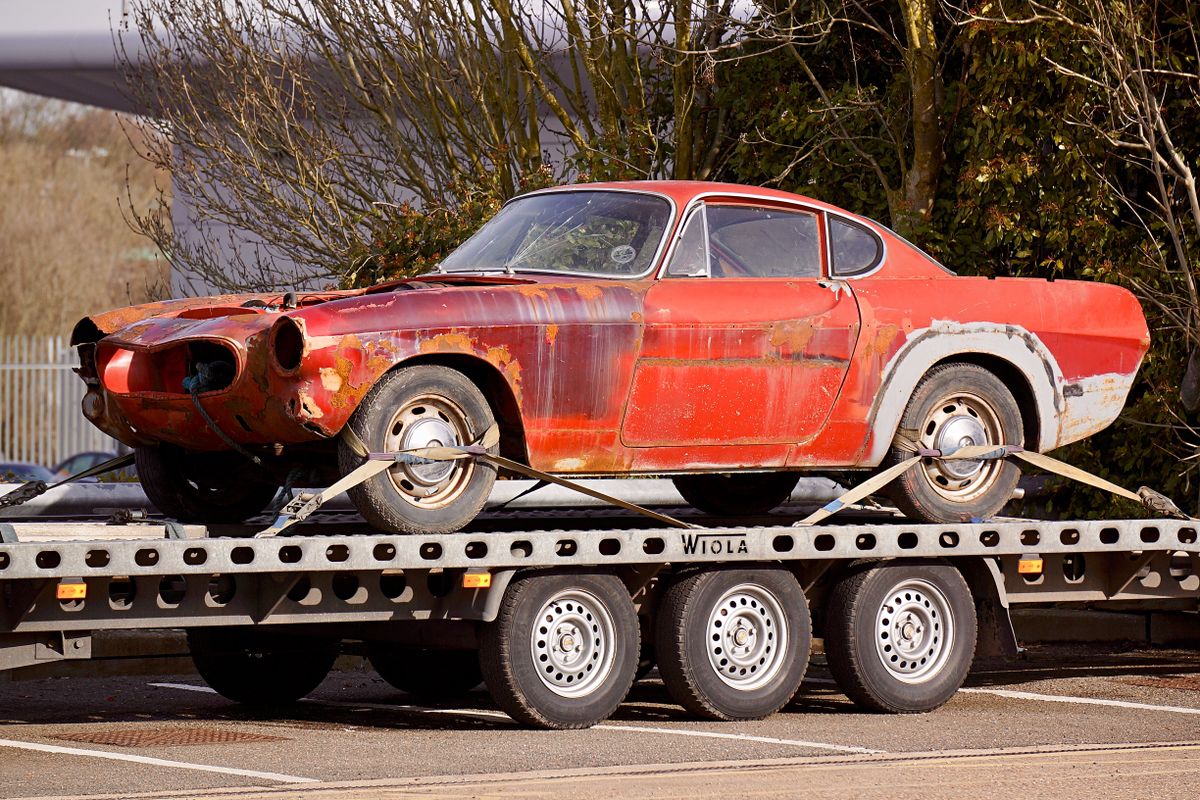 A car strapped down on the deck of a flatbed tow truck